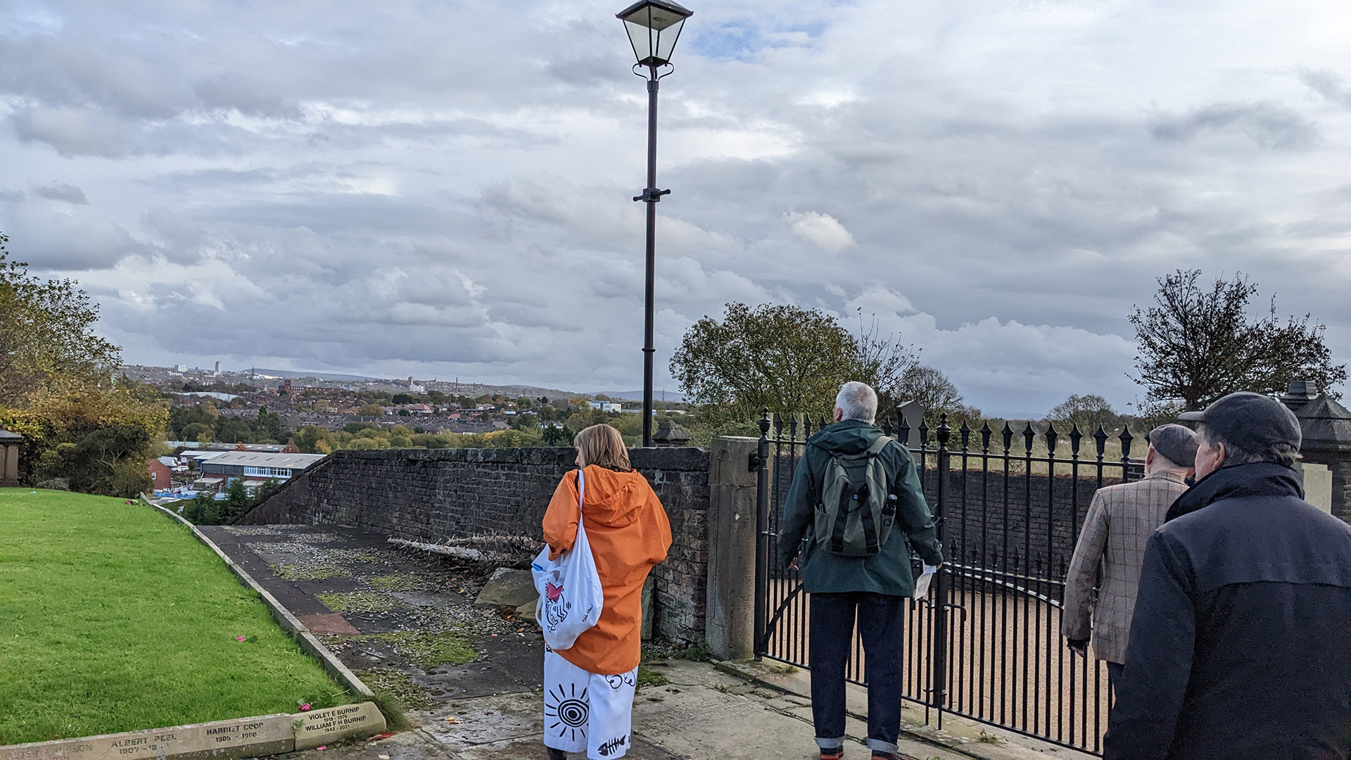 A photograph take during Stephen Marland's urban roam around Middleton. The image shows a group of people looking out across the town in the distance, from a high vantage point.