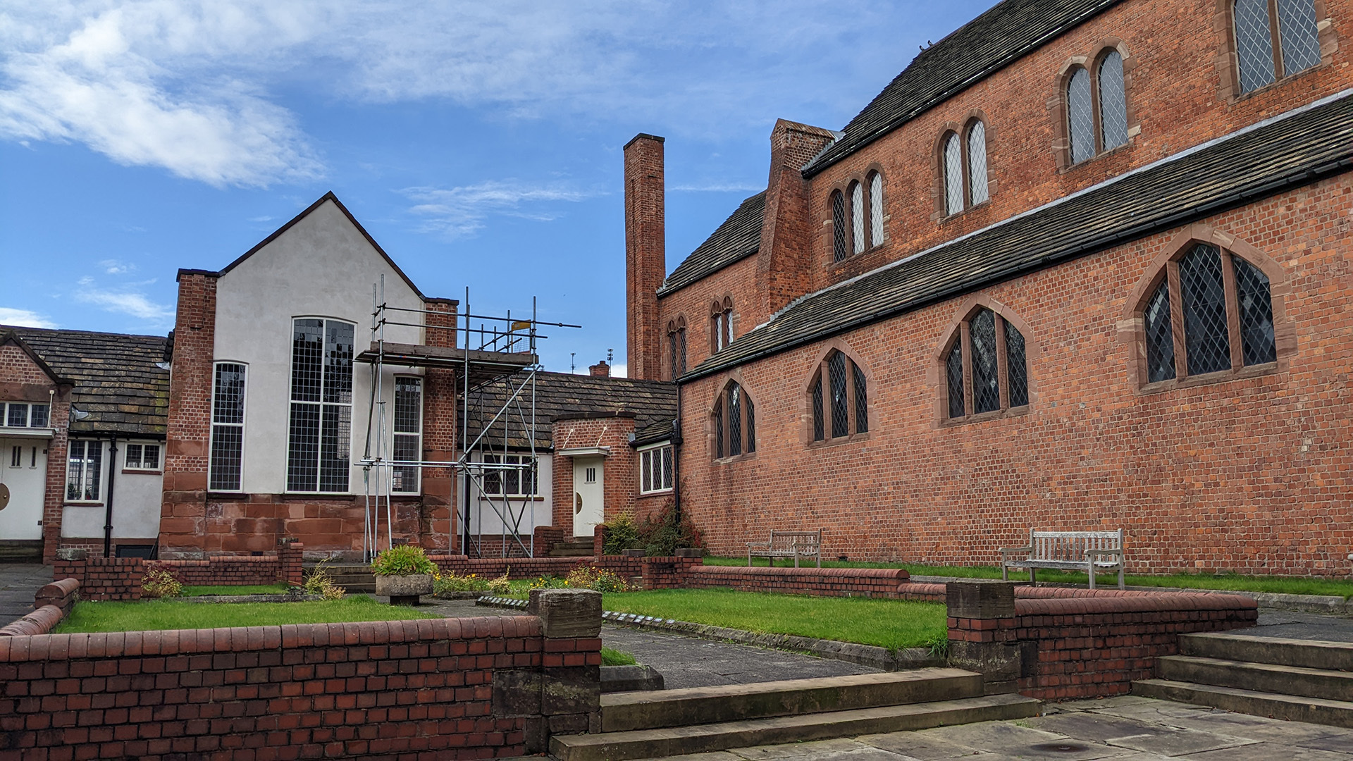 A photograph take during Stephen Marland's urban roam around Middleton. The image shows a red brick building (possibly the church) and the plain outdoor gardens of the building to the left.